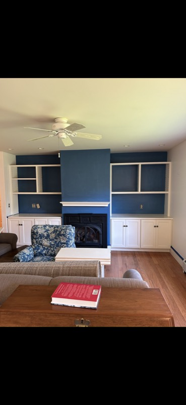Living room with navy built-in shelves around a painted fireplace wall