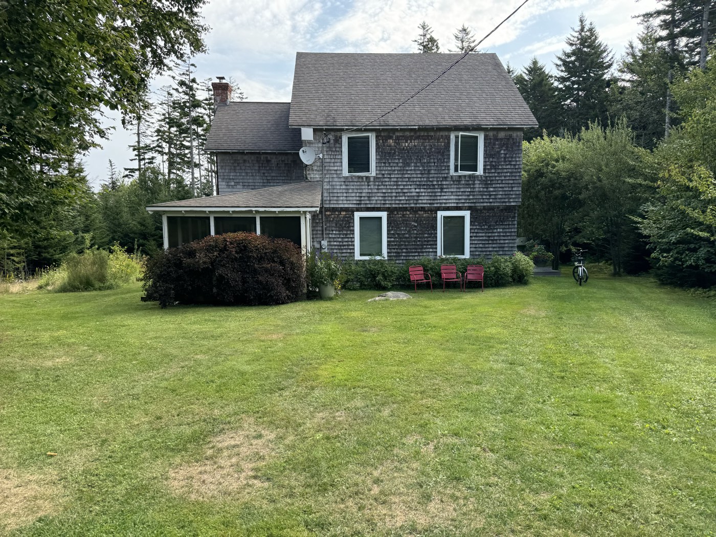 Shingled two-story home with a screened porch