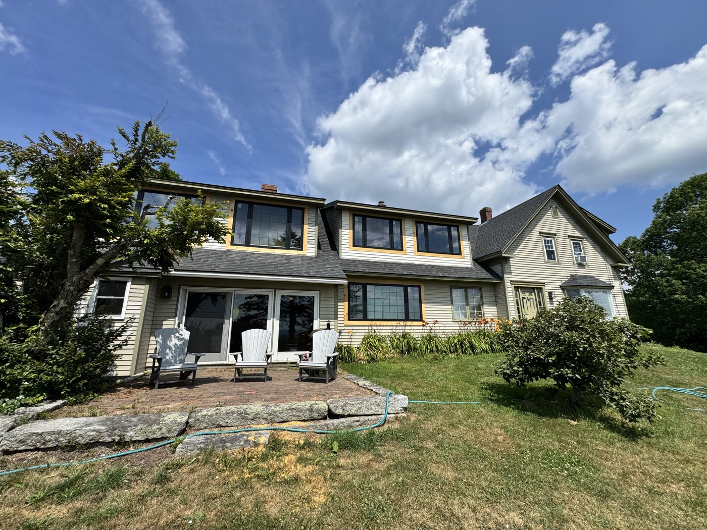 Two-story home with a stone patio after exterior painting