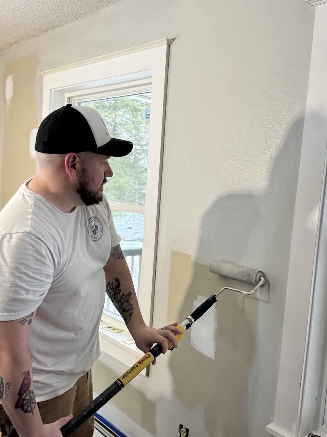 Painter rolling a fresh coat onto an interior wall