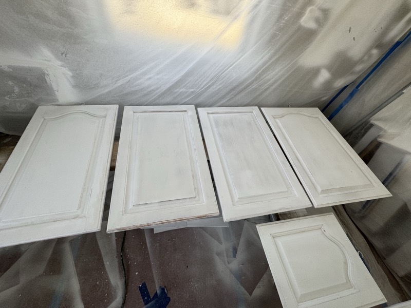 Freshly sprayed white cabinet doors laid out to cure