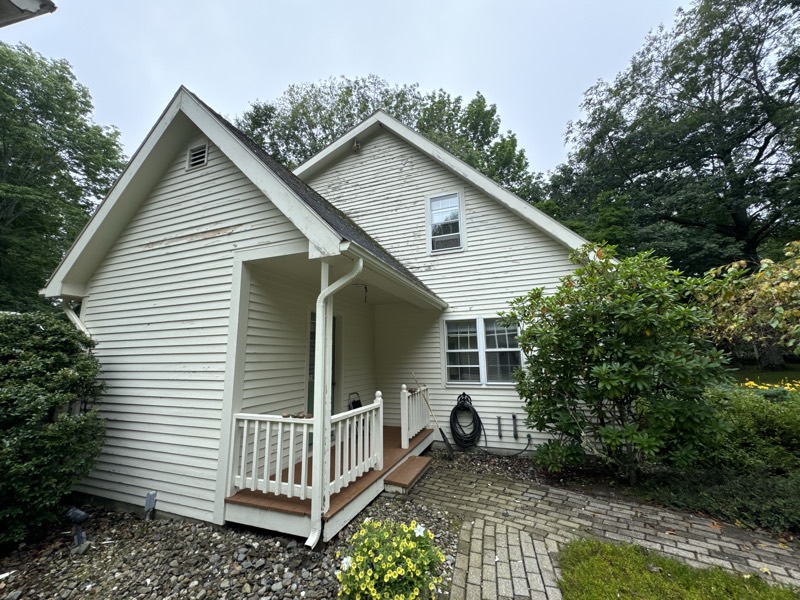 White two-story home with a freshly painted front porch and railing